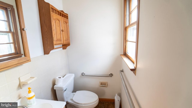 bathroom featuring tile walls, vanity, and toilet