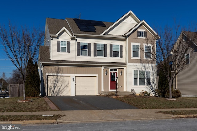 view of front of property with a garage and solar panels