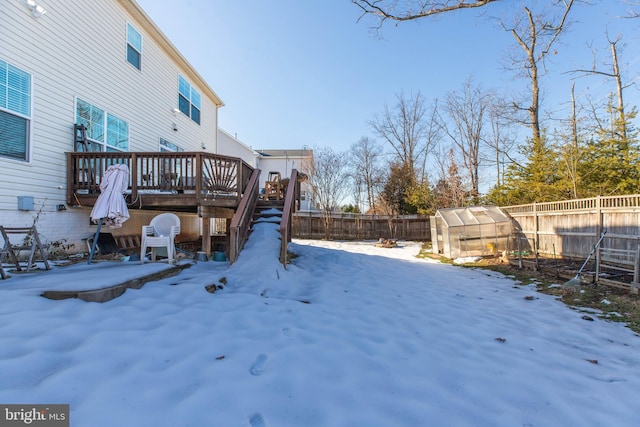 snowy yard with an outdoor structure and a deck