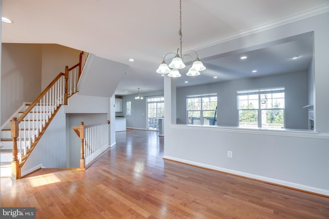 interior space featuring hardwood / wood-style floors, crown molding, and a chandelier