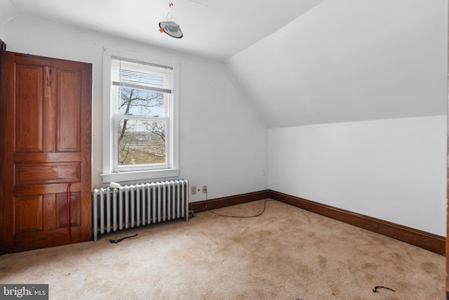 bonus room with radiator heating unit, light carpet, and vaulted ceiling