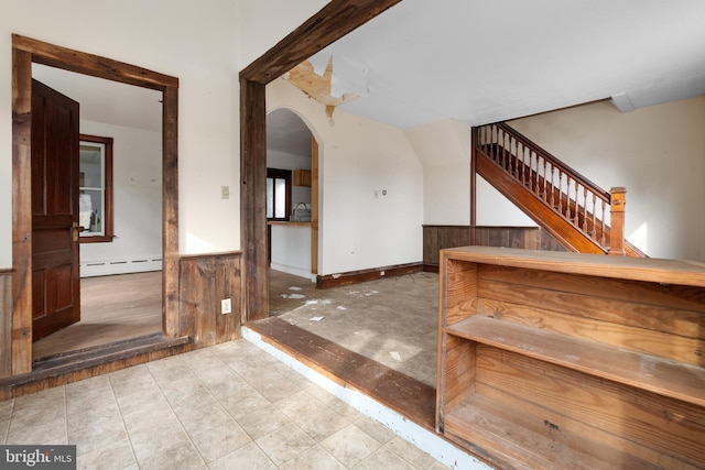 stairs with a baseboard radiator and wooden walls