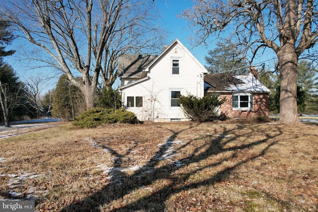 rear view of property featuring a yard