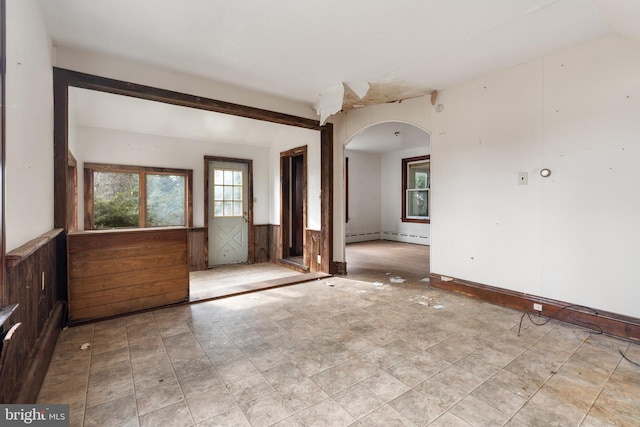 unfurnished room featuring beamed ceiling and a baseboard radiator