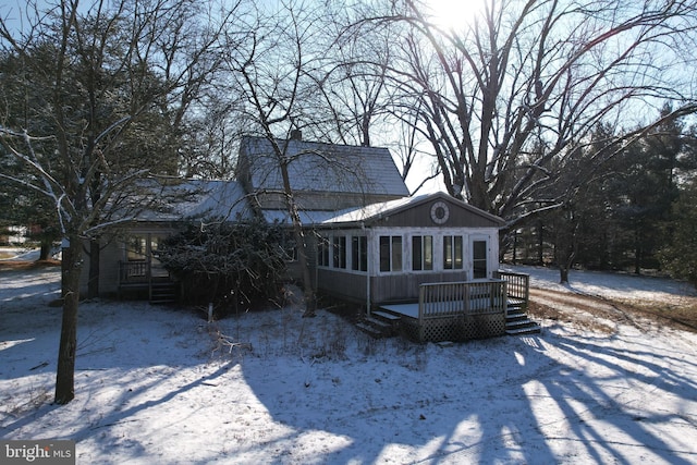 snow covered property with a sunroom