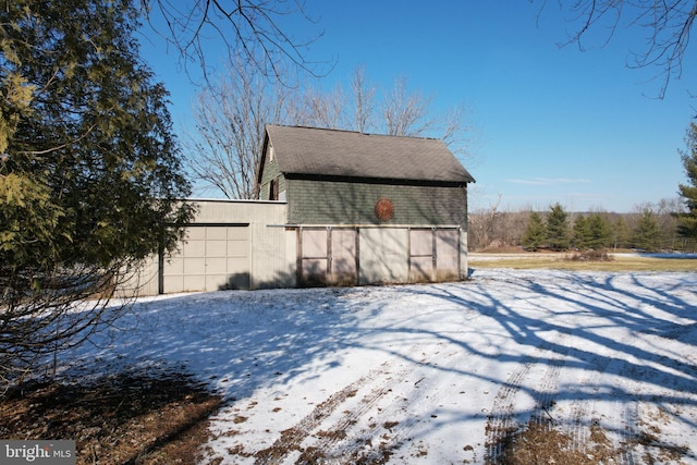 snow covered structure featuring a garage