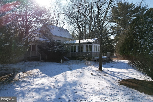 snowy yard with a sunroom