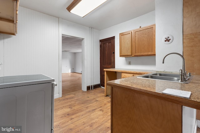 kitchen with sink, light hardwood / wood-style floors, and range