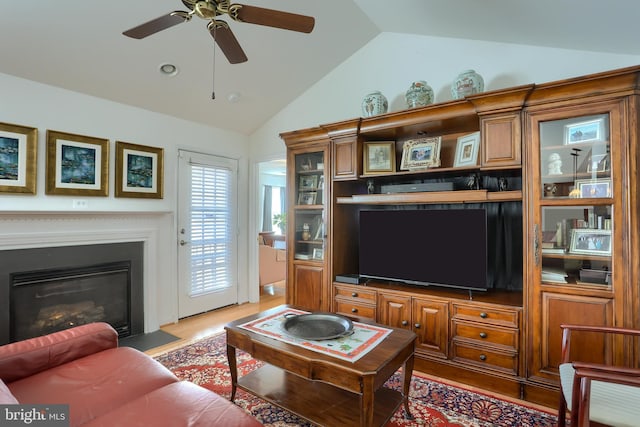 living room with vaulted ceiling, ceiling fan, and wood-type flooring