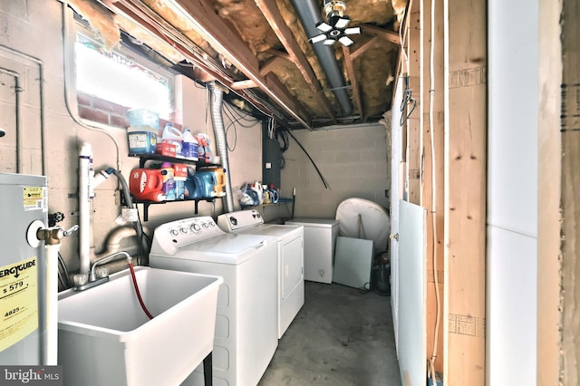 laundry area with sink, washer and clothes dryer, and water heater