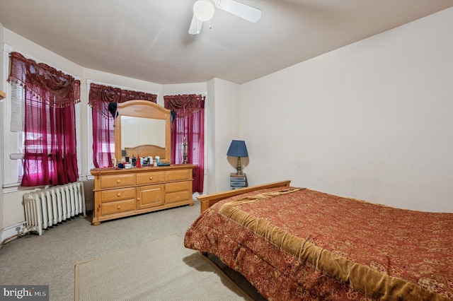 carpeted bedroom with ceiling fan and radiator heating unit