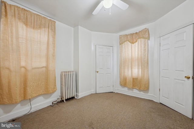 interior space featuring carpet floors, radiator, and ceiling fan