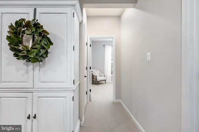 hall featuring light colored carpet