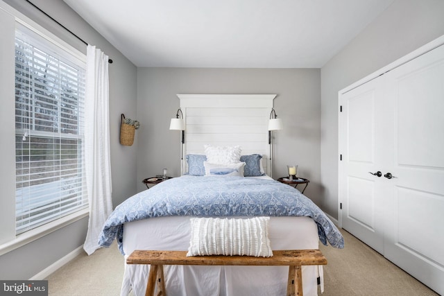 bedroom featuring multiple windows, a closet, and carpet