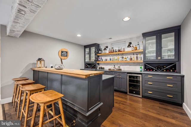 bar with gray cabinetry, dark wood-type flooring, beverage cooler, and wooden counters