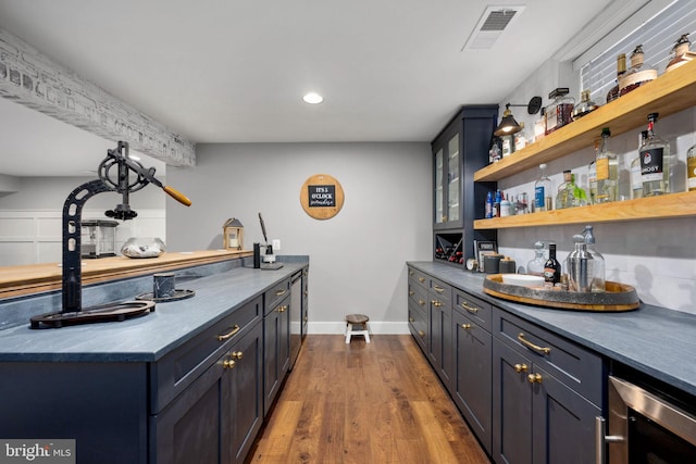 bar with wine cooler and hardwood / wood-style flooring