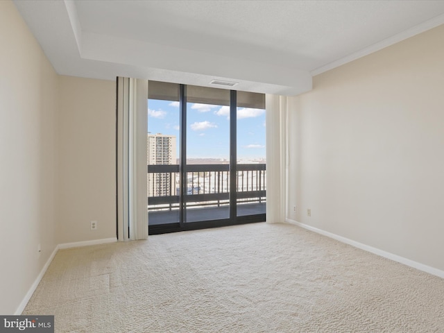 spare room with expansive windows, ornamental molding, and carpet floors