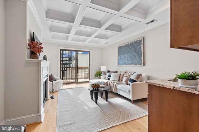 living room featuring light hardwood / wood-style floors, ornamental molding, beamed ceiling, and coffered ceiling