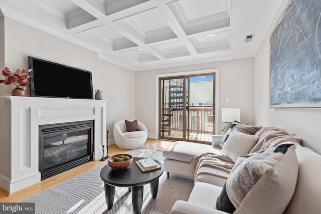 living room featuring coffered ceiling, light hardwood / wood-style flooring, beam ceiling, and ornamental molding