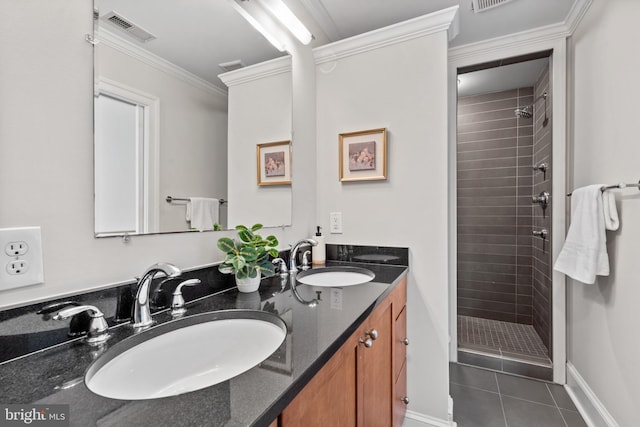 bathroom with tiled shower, vanity, ornamental molding, and tile patterned flooring