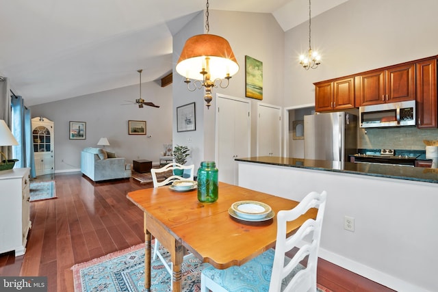 dining space featuring vaulted ceiling, ceiling fan with notable chandelier, and dark hardwood / wood-style floors