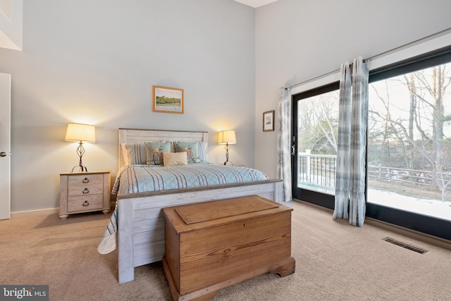 bedroom featuring access to exterior and light carpet