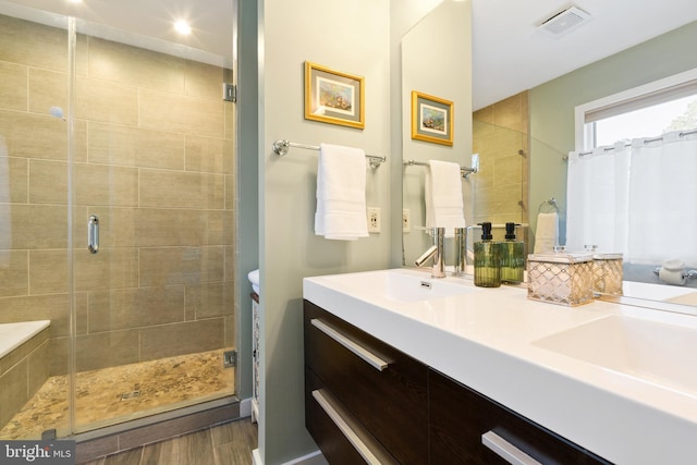 bathroom with vanity and a shower with door