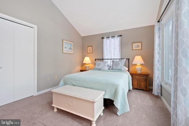 carpeted bedroom with a closet and vaulted ceiling