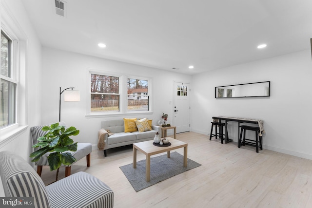 living room featuring plenty of natural light and light hardwood / wood-style flooring