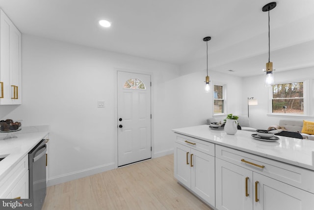 kitchen featuring decorative light fixtures, light stone countertops, white cabinets, and dishwasher