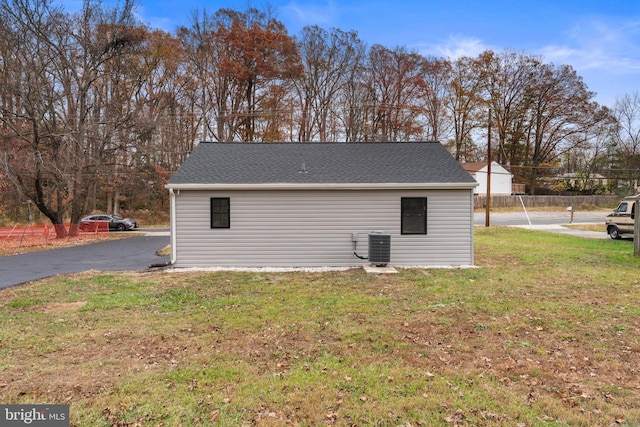 view of outbuilding with cooling unit and a yard