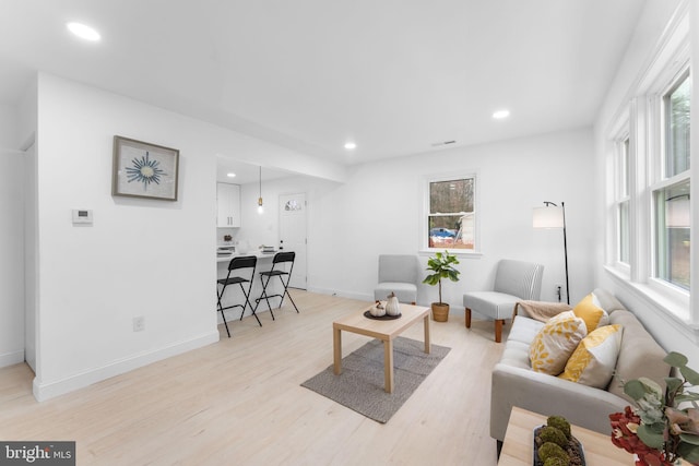 living room with plenty of natural light and light hardwood / wood-style flooring