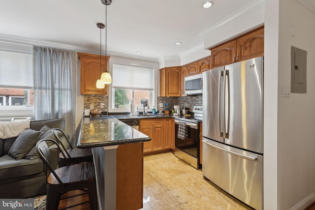 kitchen with kitchen peninsula, appliances with stainless steel finishes, decorative backsplash, hanging light fixtures, and dark stone counters