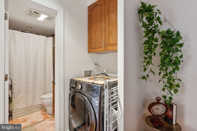 washroom with washer / dryer and cabinets