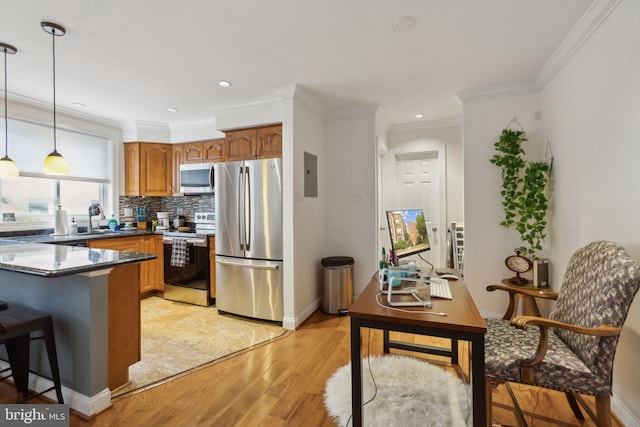 kitchen featuring decorative light fixtures, stainless steel appliances, decorative backsplash, ornamental molding, and light wood-type flooring