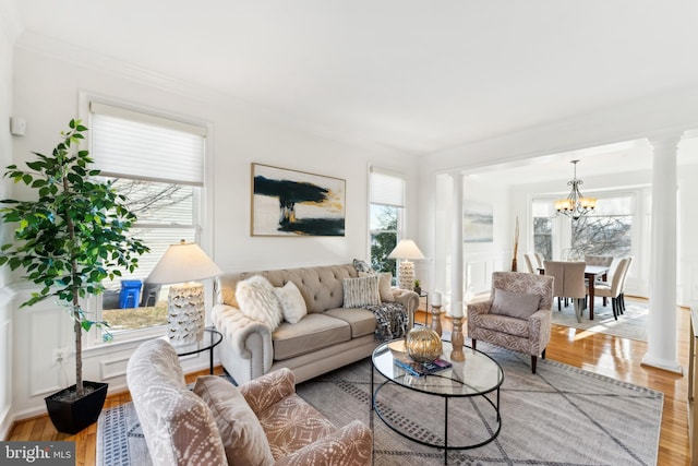 living room featuring wood-type flooring, a healthy amount of sunlight, and crown molding