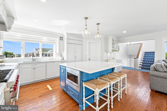 kitchen featuring white cabinets, built in appliances, and a center island