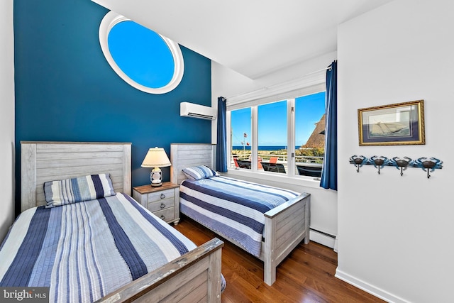 bedroom with dark hardwood / wood-style flooring, a baseboard radiator, and a wall unit AC