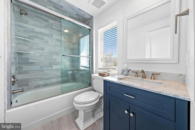 full bathroom featuring toilet, enclosed tub / shower combo, and vanity