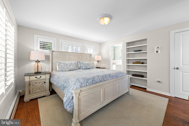 bedroom featuring a baseboard heating unit and dark hardwood / wood-style floors