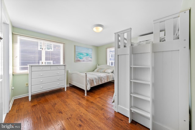 bedroom with dark hardwood / wood-style flooring and multiple windows