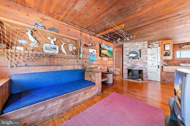 living room featuring wood-type flooring, wood ceiling, and wooden walls