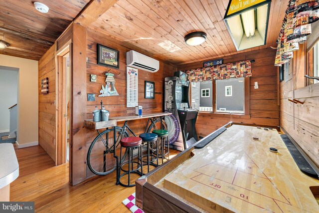 interior space featuring light hardwood / wood-style flooring, wood ceiling, wooden walls, and a wall unit AC