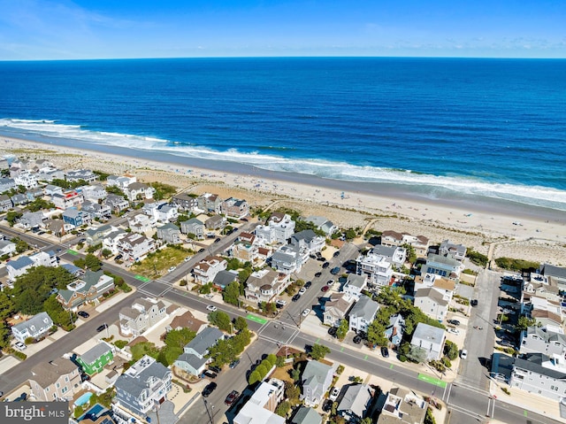 drone / aerial view featuring a water view and a beach view