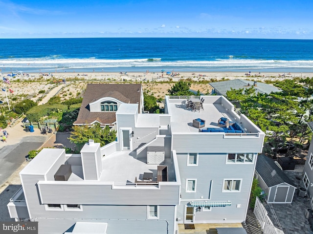 birds eye view of property with a water view and a view of the beach