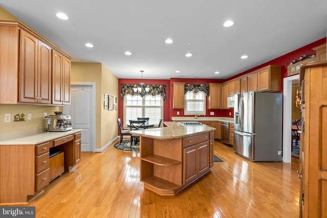 kitchen featuring a notable chandelier, a center island, pendant lighting, light hardwood / wood-style floors, and stainless steel appliances