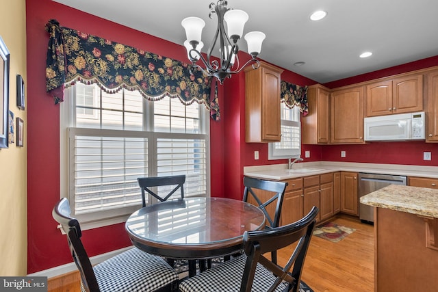 kitchen with light hardwood / wood-style floors, a notable chandelier, sink, dishwasher, and pendant lighting