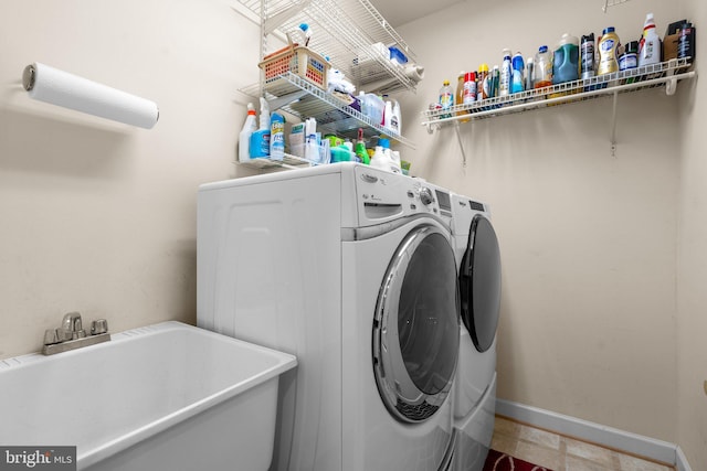 washroom with sink and washing machine and clothes dryer