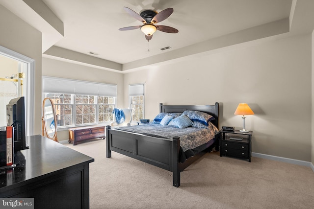 bedroom featuring a tray ceiling, ceiling fan, and light colored carpet