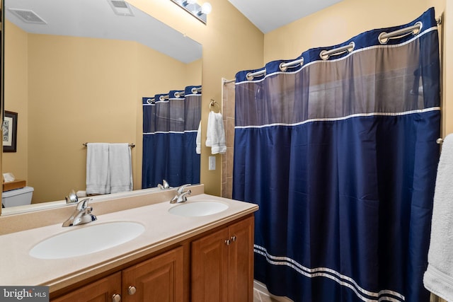 bathroom featuring toilet, curtained shower, and vanity